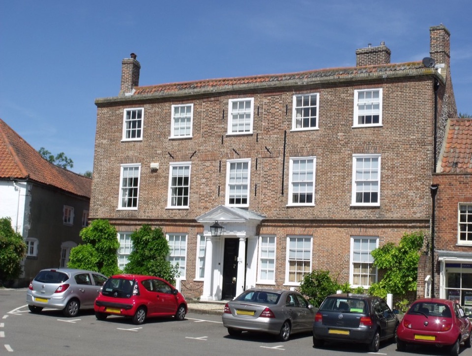 A brick fronted Georgian house with sash windows on the green at Burnham Market in Norfolk